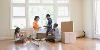 A group of people in the living room with boxes.