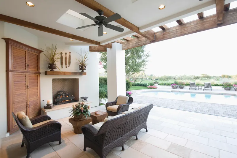 A patio with furniture and a fireplace in the middle of it.